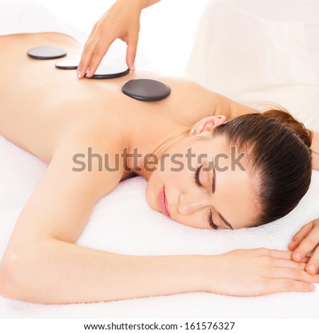 Adult  woman having hot stone massage in spa salon. Beauty treatment concept.