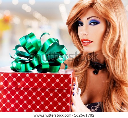 Portrait of a beautiful sexy adult  woman with a birthday gift red box  with green ribbon - indoors