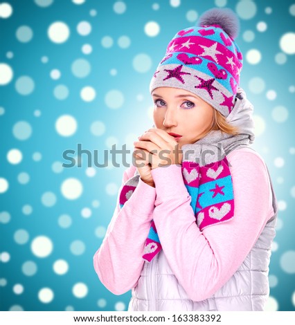 beautiful young woman in winter clothes warming her hands with snow falls