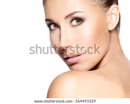 Beautiful young woman with clear skin that looks at the camera; closeup, isolated on white.