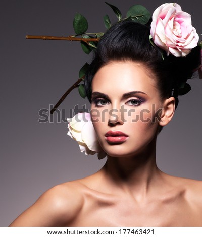 Portrait of a beautiful brunette woman with creative hairstyle. Posing at studio.