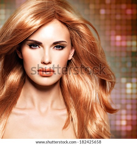 Portrait of a beautiful woman with long straight red hair and glamour makeup .