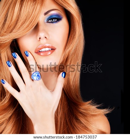 portrait of a beautiful woman with blue nails, blue makeup and  long red hairs  on black background