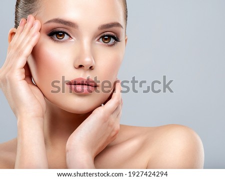 Closeup portrait of a  face of the young pretty girl with a healthy skin. Beautiful face of young white woman with a clean skin. Skin care concept. 