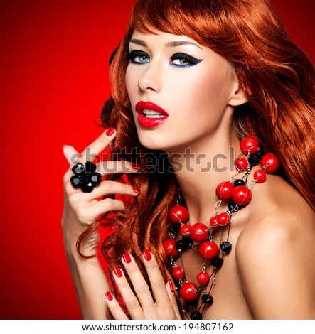 Beautiful sensual woman with long red hairs and red nails -  red background