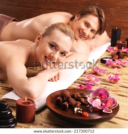 Happy smiling couple lying on the massage desks on the spa salon. Beauty treatment concept.