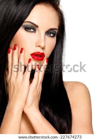 Closeup face of a beautiful brunette woman with red nails and lips - isolated on white background