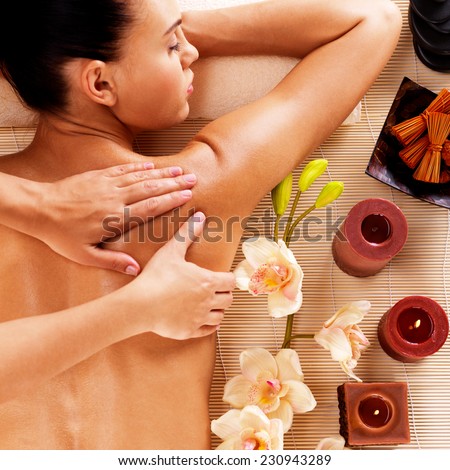 Adult woman in spa salon having body relaxing massage.