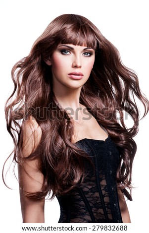 Beautiful young woman with long brown hair. Pretty model poses at studio.