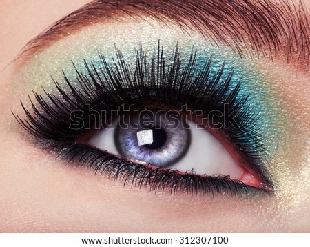 Woman\'s eye with green eye make-up. Long eyelashes