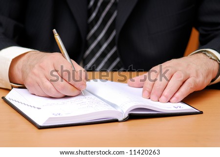 businessman write down to the datebook