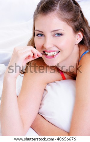 Beauty happy face of a young female biting her lock of hairs