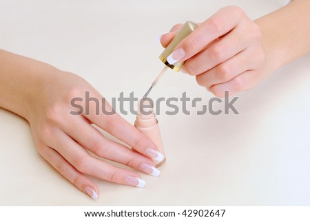 Macro shot of a female  brushing her fingernails with enamel