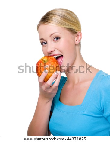 Portrait of a happy beautiful girl biting the fresh red apple - over white background. Copy space