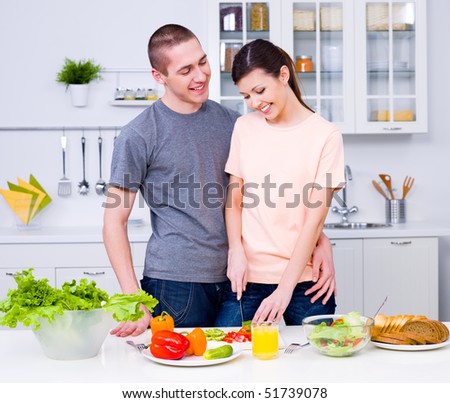 Happy young couple making a breakfast together in the kitchen