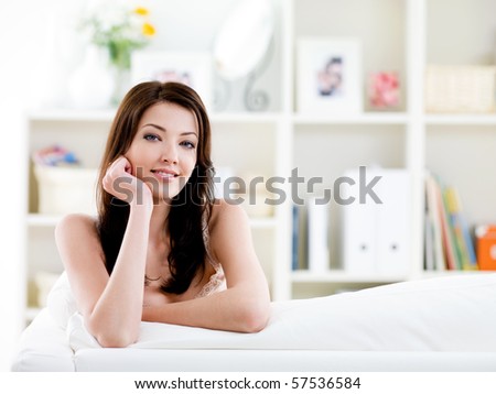 Portrait of young beautiful brunette woman with easy smile at home - indoors