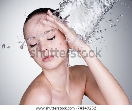 Water falling on the beautiful sensuality woman face with clean skin - horizontal