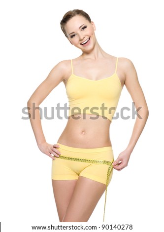 Laughing woman with sexy slim body measuring hips with  measurement type - isolated on white.