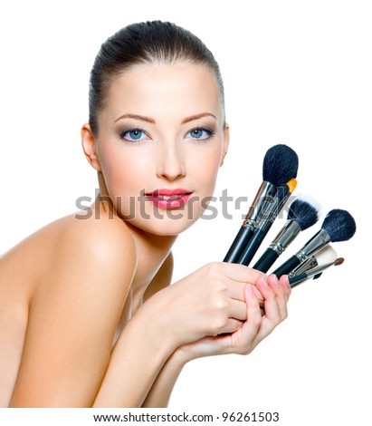 Portrait of the beautiful woman with makeup brushes near  face