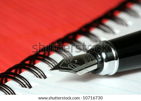 pen with notebook on red bamboo mat