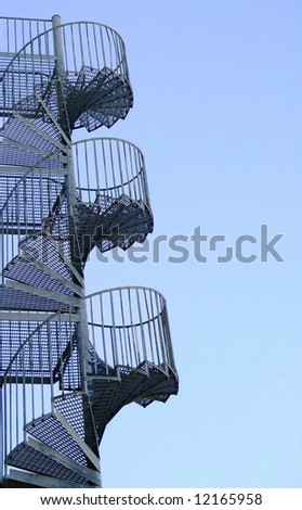 a metal spiral fire escape on the side of a block of flats