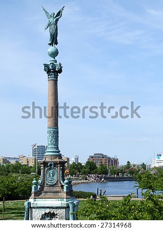 one of copenhagen\'s many impressive statues with hans christian anderson\'s little mermaid in the background