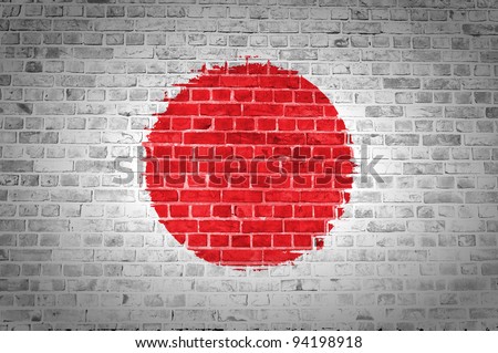 An image of the Japan flag painted on a brick wall in an urban location