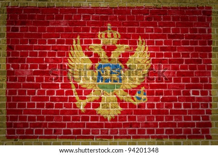An image of the Montenegro flag painted on a brick wall in an urban location