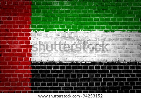 An image of the United Arab Emirates flag painted on a brick wall in an urban location