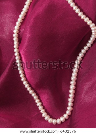a string of beads on the satin background