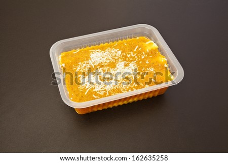 Cannelloni with riocata and tomato sauce in opened package for freezing or to go on white background.