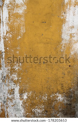A yellow wall needing a new paint and repair in holes, cracks and mold.