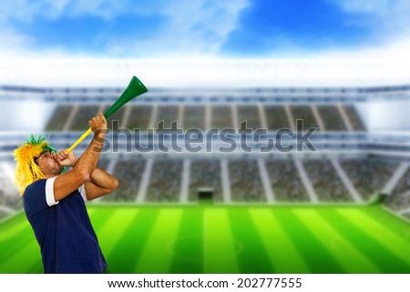 Brazilian fan at stadium playing vuvuzela for celebrating a brazil team goal