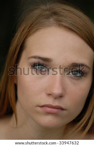 A close up portrait of a girl with beautiful eyes and a sullen expression.