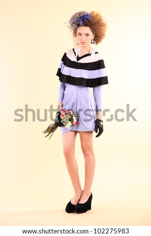 Fashion model in spring light purple clothes on beige background.