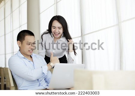 Couple of professionals debating in front of a laptop display