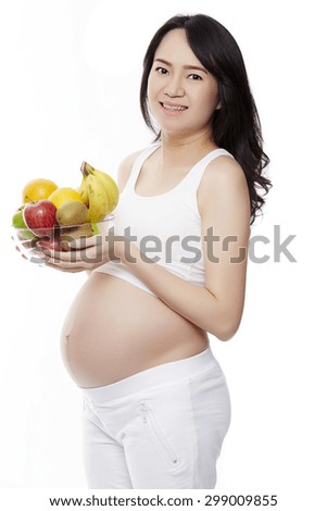 Pregnancy and nutrition - pregnant woman with fruits on isolate white background.