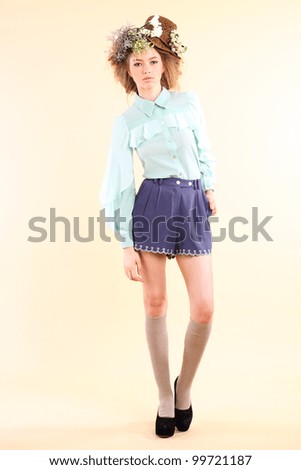Fashion model in spring light blue and purple clothes on beige background.