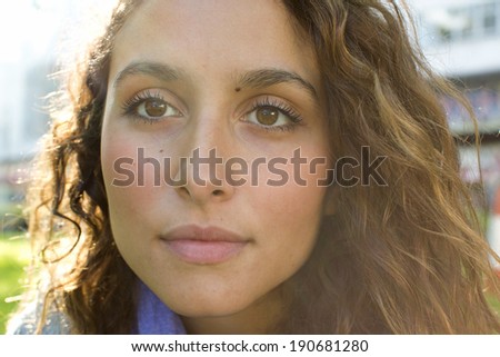 Portrait of a young attractive woman gazing off camera whilst thinking on a bright sunny day