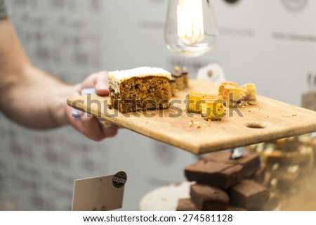 Wooden platter of cake samples being handed over