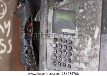 Vandalized payphone that has been burnt and melted beyond repair