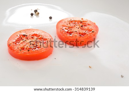 Closeup Of Two Tomato Slices On Glass Cutting Board