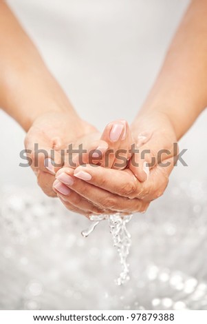 Washing hands above the sink with splashing and drops
