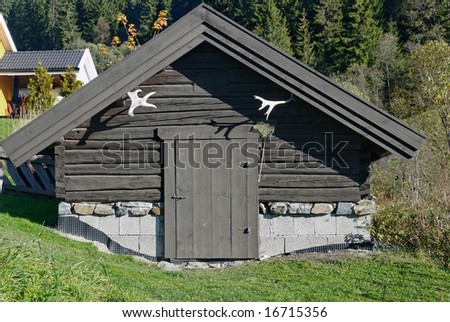 A small traditional Norwegian storage house or cellar, made of tared timber with moose horns.