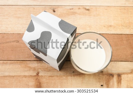 glass of milk, a carton of milk on wooden table.