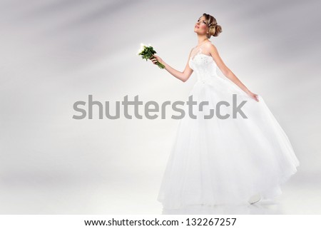 beautiful young bride wearing wedding dress holding white flowers