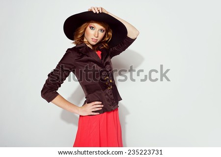 beautiful red-haired woman in a black broad-brim hat in stylish clothes