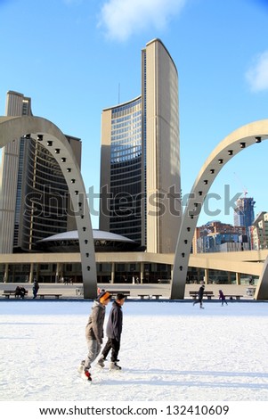 TORONTO - MARCH 16: Skating on Nathan Phillips Square outdoor rink in Toronto on March 16, 2013. In Winter, the City Hall pool is frozen into a popular outdoor skating rink.