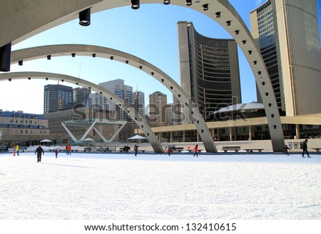 TORONTO - MARCH 16: Skating on Nathan Phillips Square outdoor rink in Toronto on March 16, 2013. In Winter, the City Hall pool is frozen into a popular outdoor skating rink.