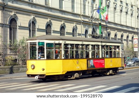 MILAN, ITALY - APRIL 26, 2014: Orange vintage tram in a street of Milan city center.